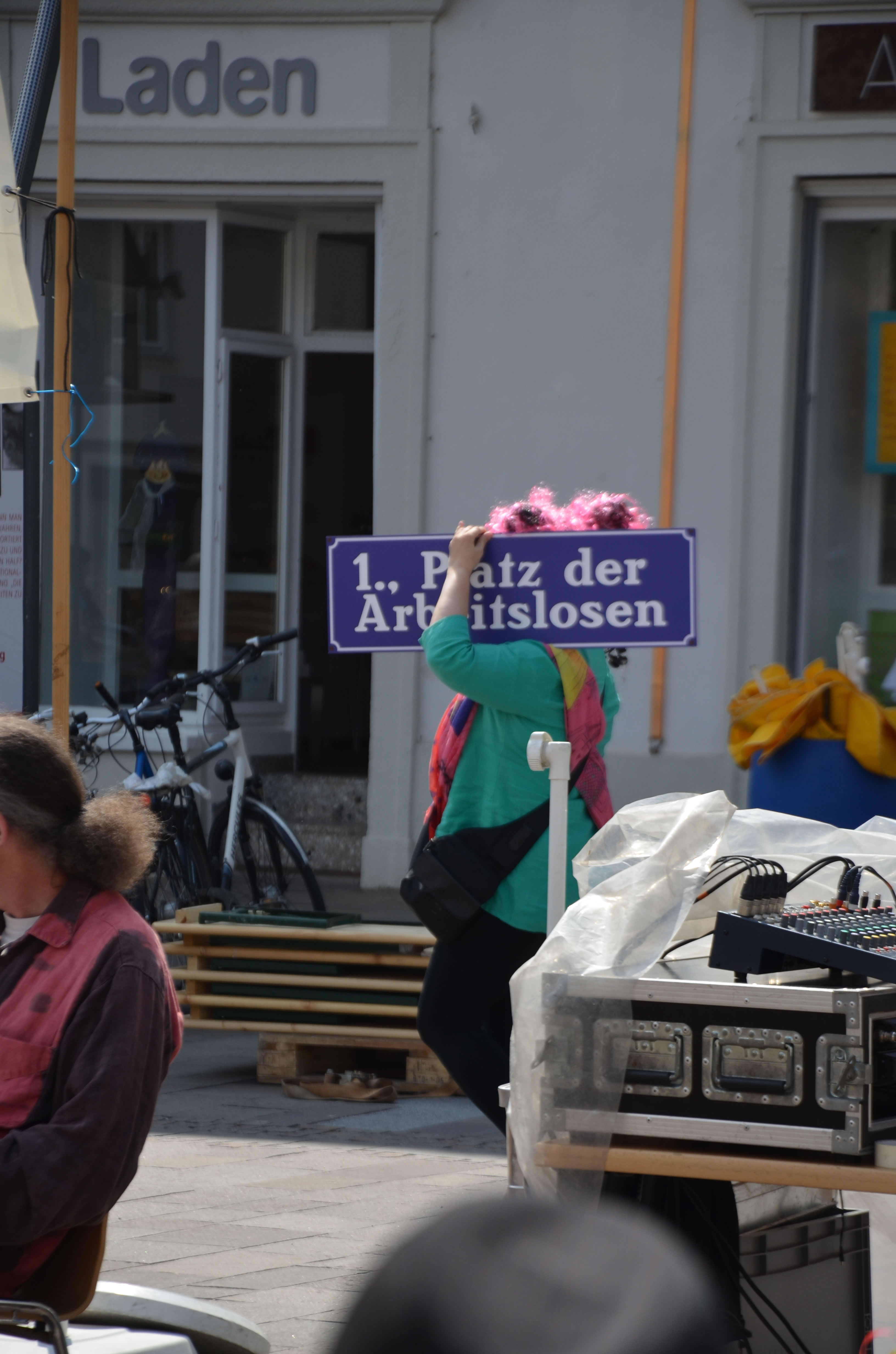 Betty Baloo am Tag der Arbeitslosen 2014 in Graz Mariahilfer Platz mit Schild gehend